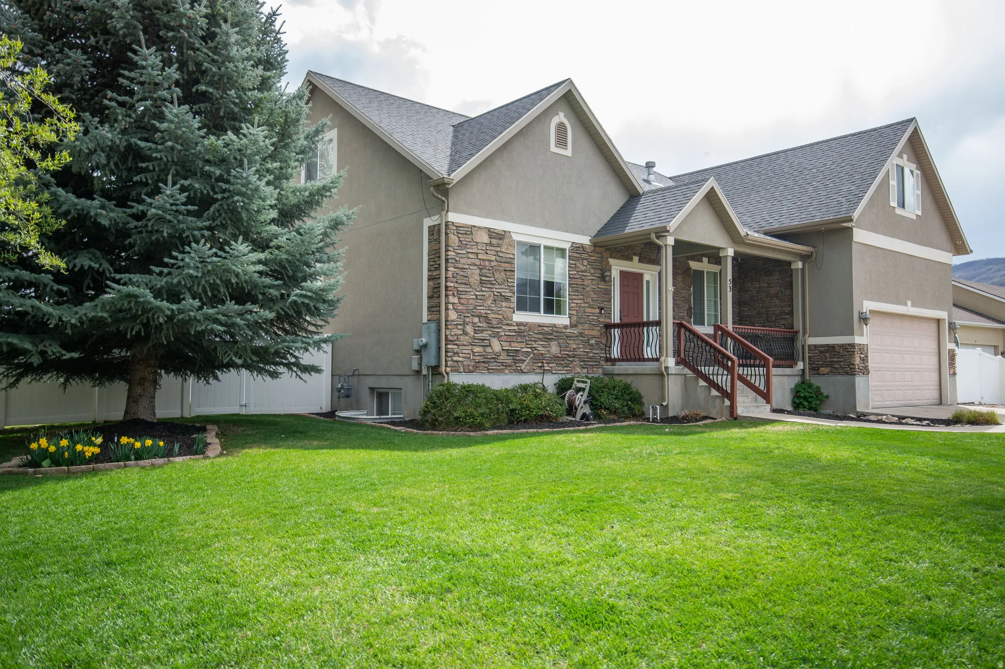 Craftsman house with stucco siding, stone siding, a garage, covered porch, and roof with shingles
