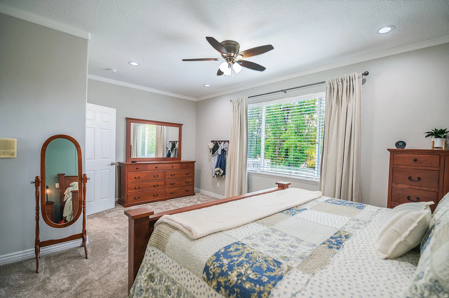 Bedroom featuring ornamental molding, a ceiling fan, carpet, and a textured ceiling