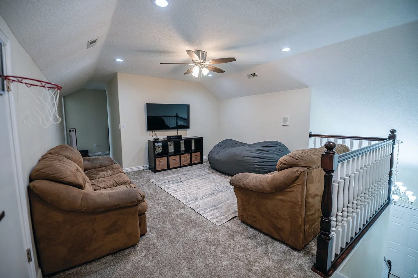 Living area featuring carpet, a ceiling fan, a textured ceiling, recessed lighting, and lofted ceiling