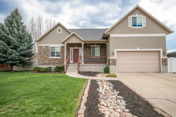 View of front of house with a porch, stone siding, stucco siding, driveway, and roof with shingles