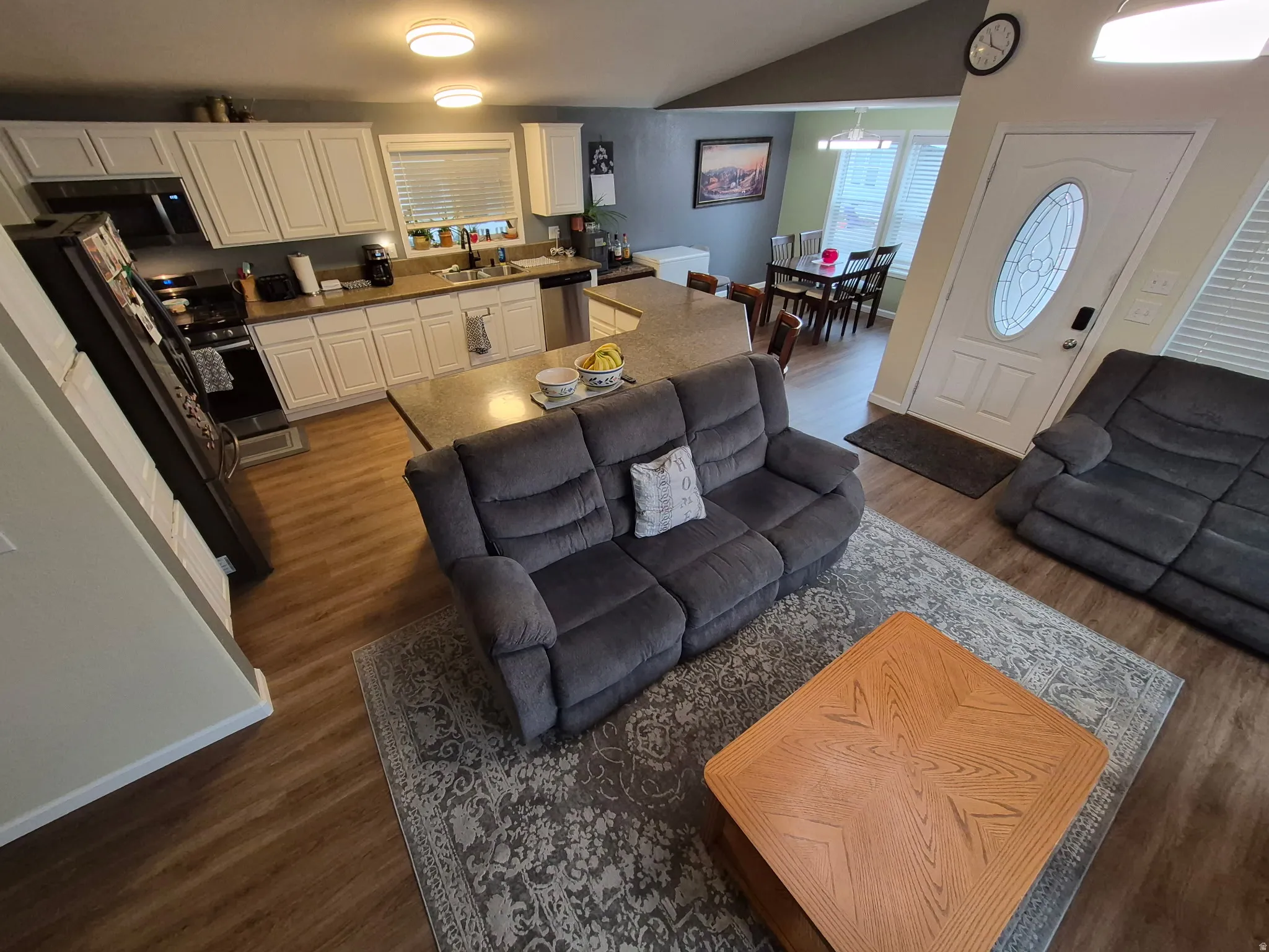 Living room featuring dark wood-style flooring and lofted ceiling