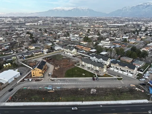 Aerial view of property and surrounding area featuring a mountain backdrop