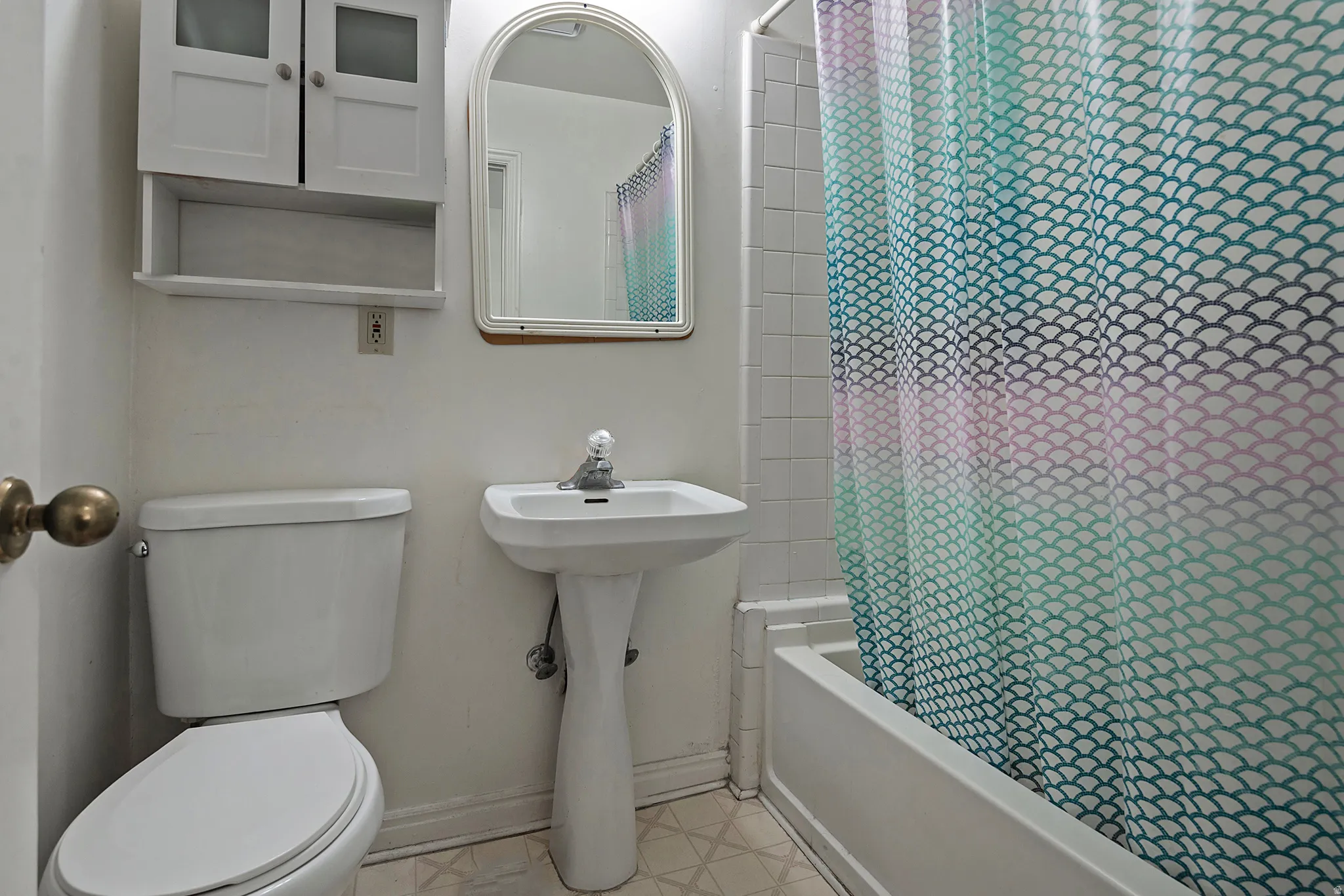 Bathroom featuring shower / bath combo and light floors
