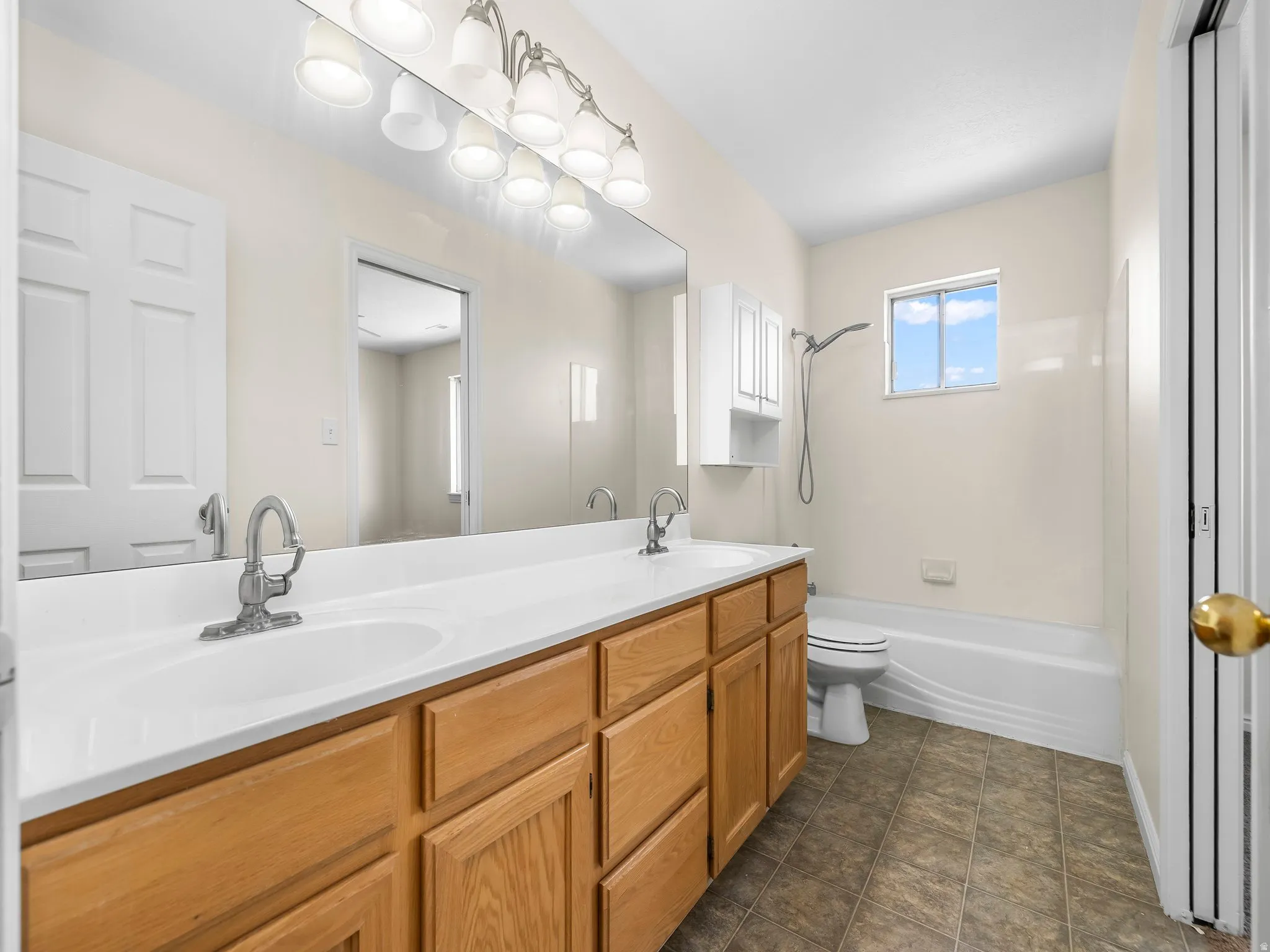 Full bathroom featuring double vanity and shower / tub combination