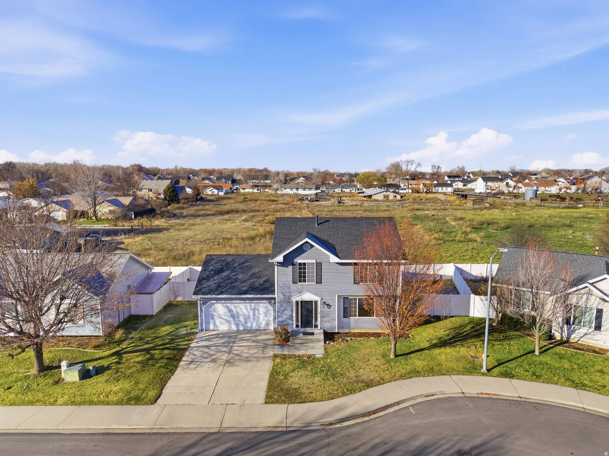 View of front of house with a residential view, driveway, a front lawn, and a garage