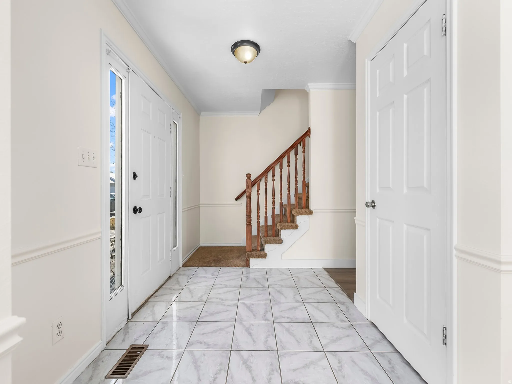 Entrance foyer with crown molding and stairs
