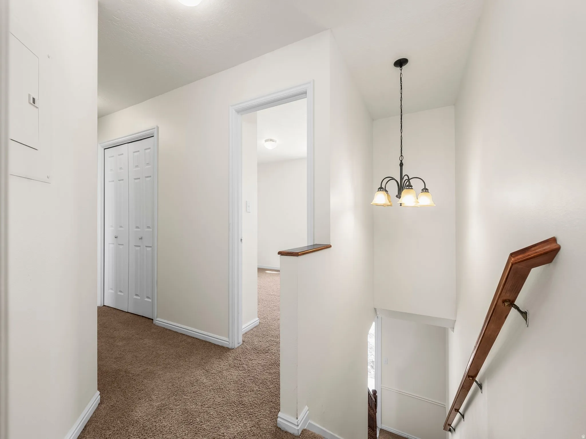 Hallway featuring an upstairs landing and carpet flooring