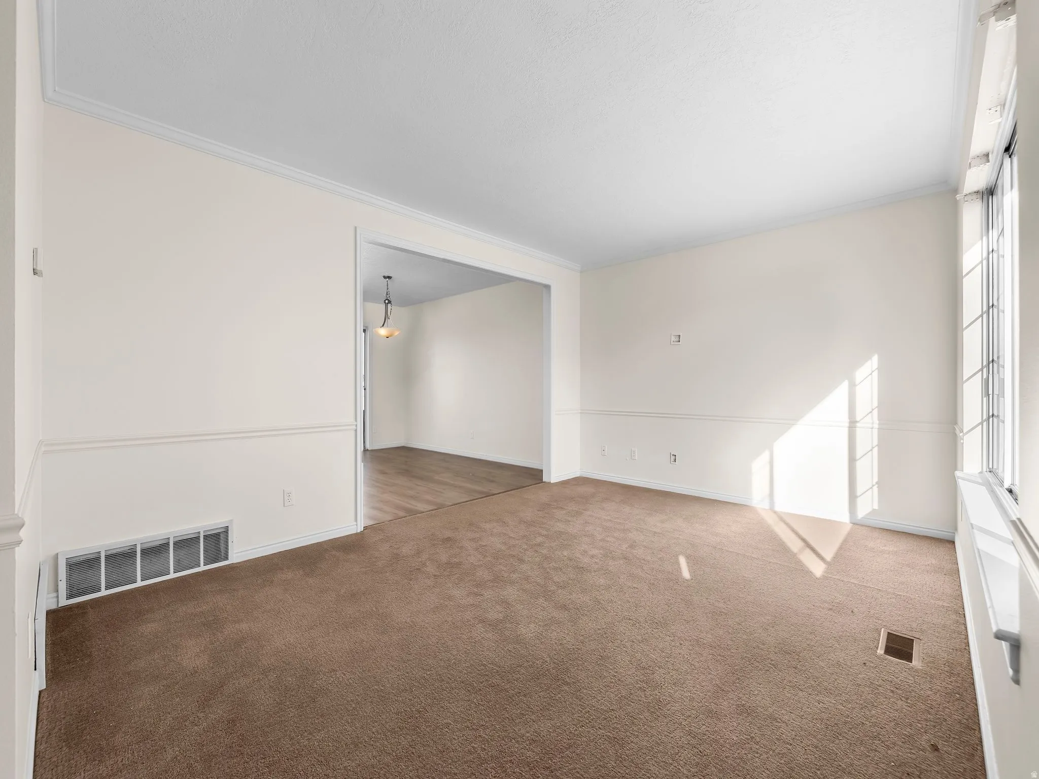 Carpeted spare room with crown molding