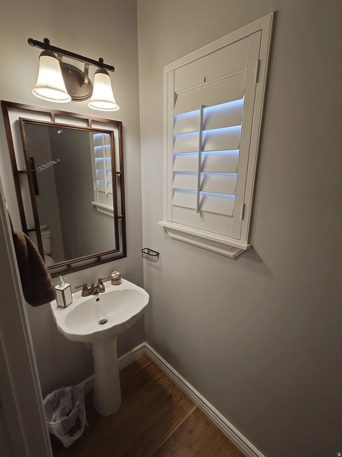 Bathroom featuring baseboards and dark wood-type flooring