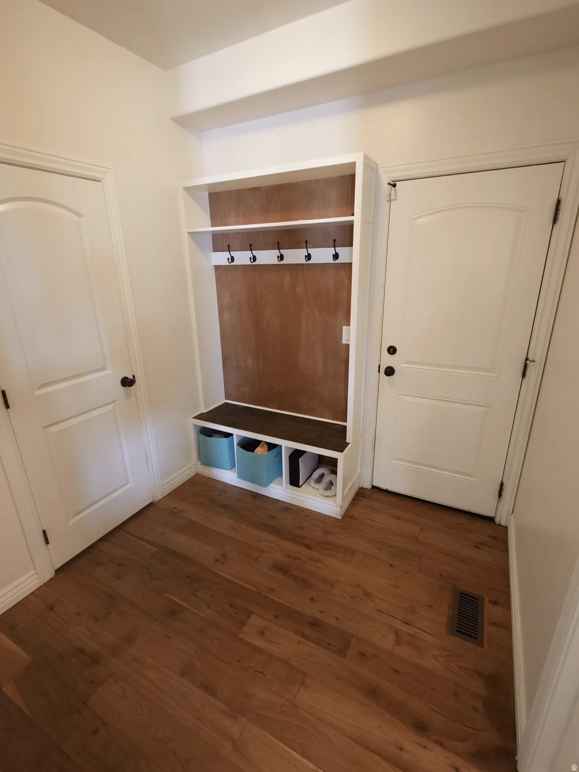 Mudroom with dark wood-style floors and baseboards