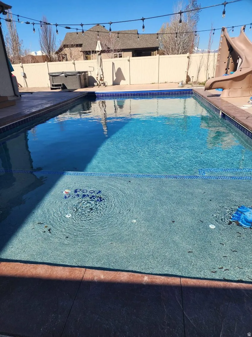 View of swimming pool featuring a fenced backyard and a patio area