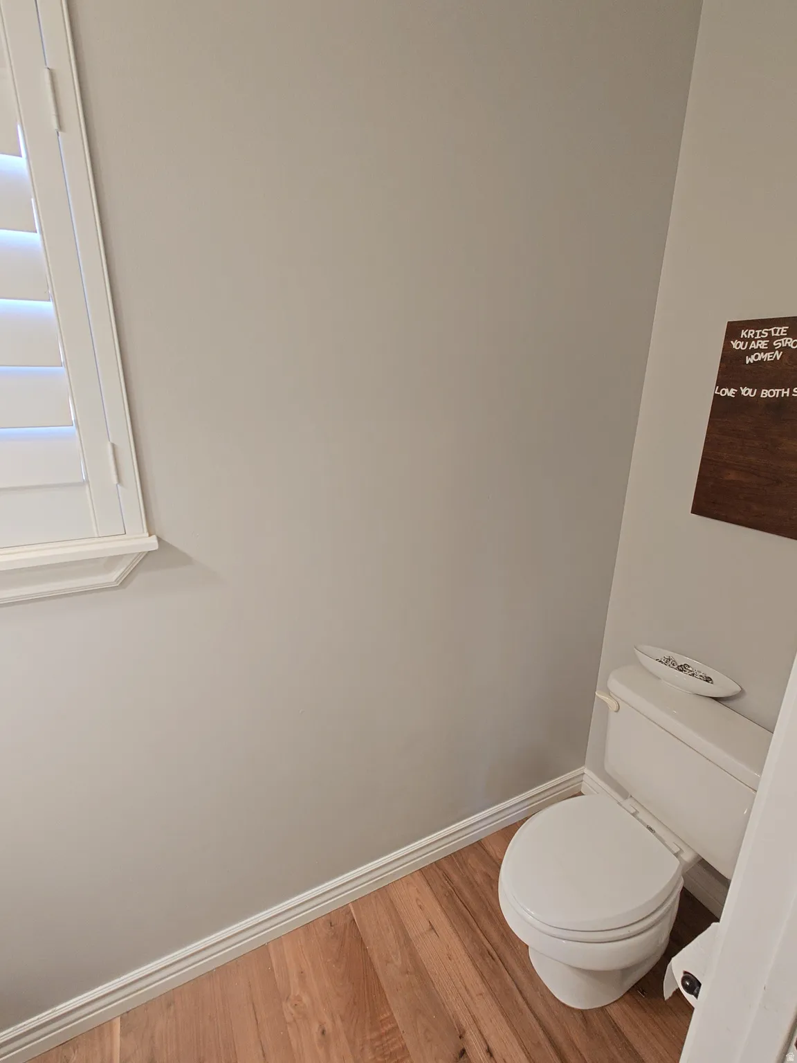 Half bath featuring baseboards and wood finished floors