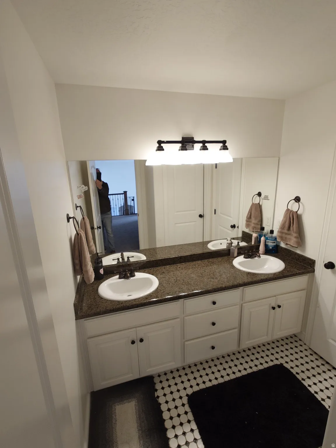 Bathroom with double vanity and light floors