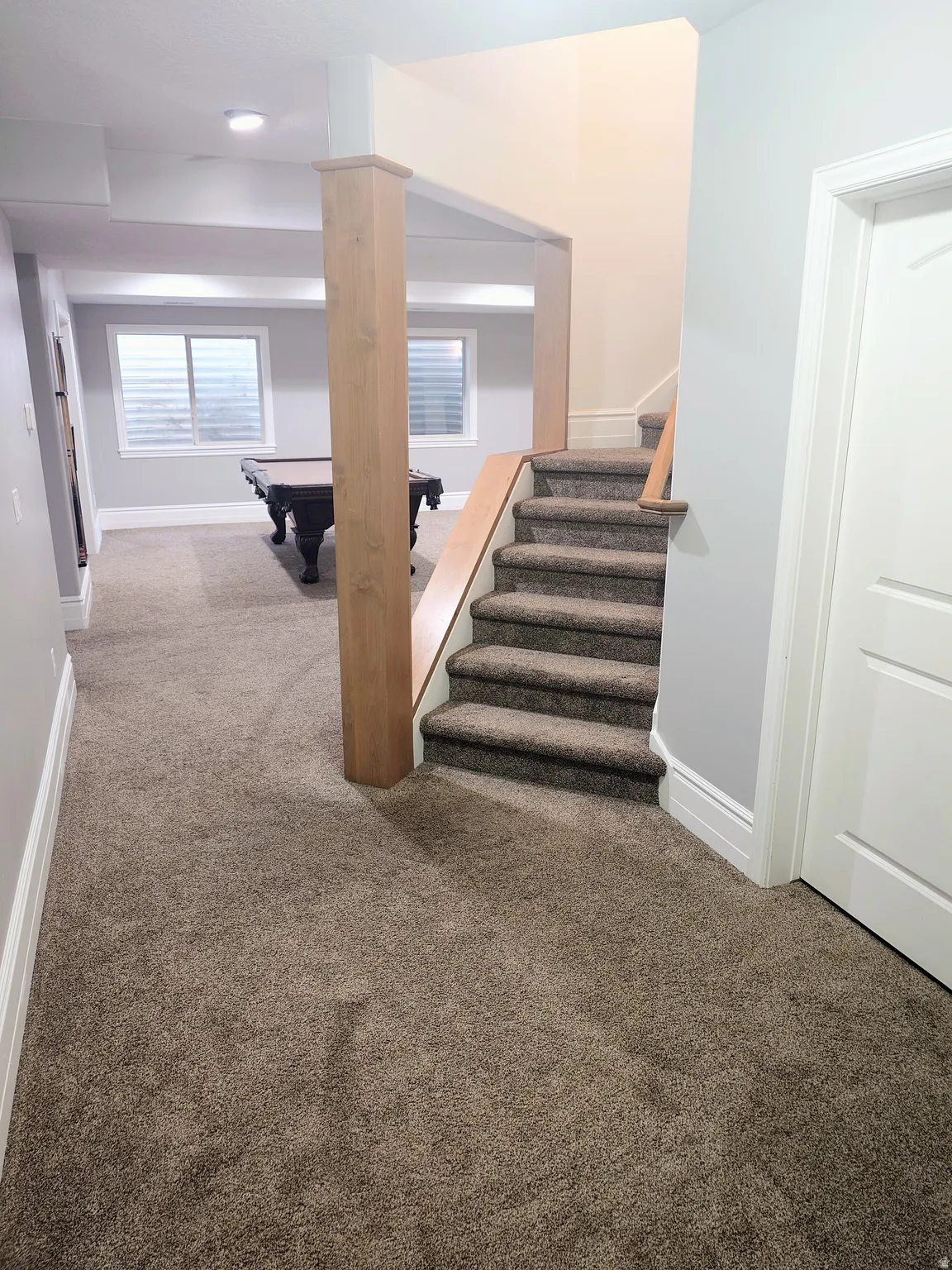 Staircase with carpet floors and billiards table