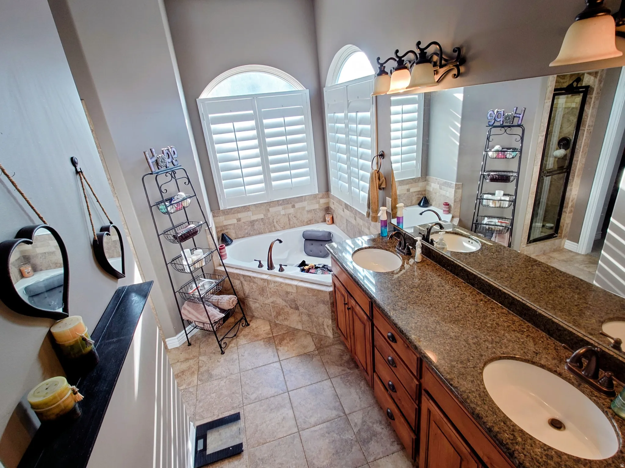 Bathroom featuring double vanity, a bath, and light tile patterned flooring