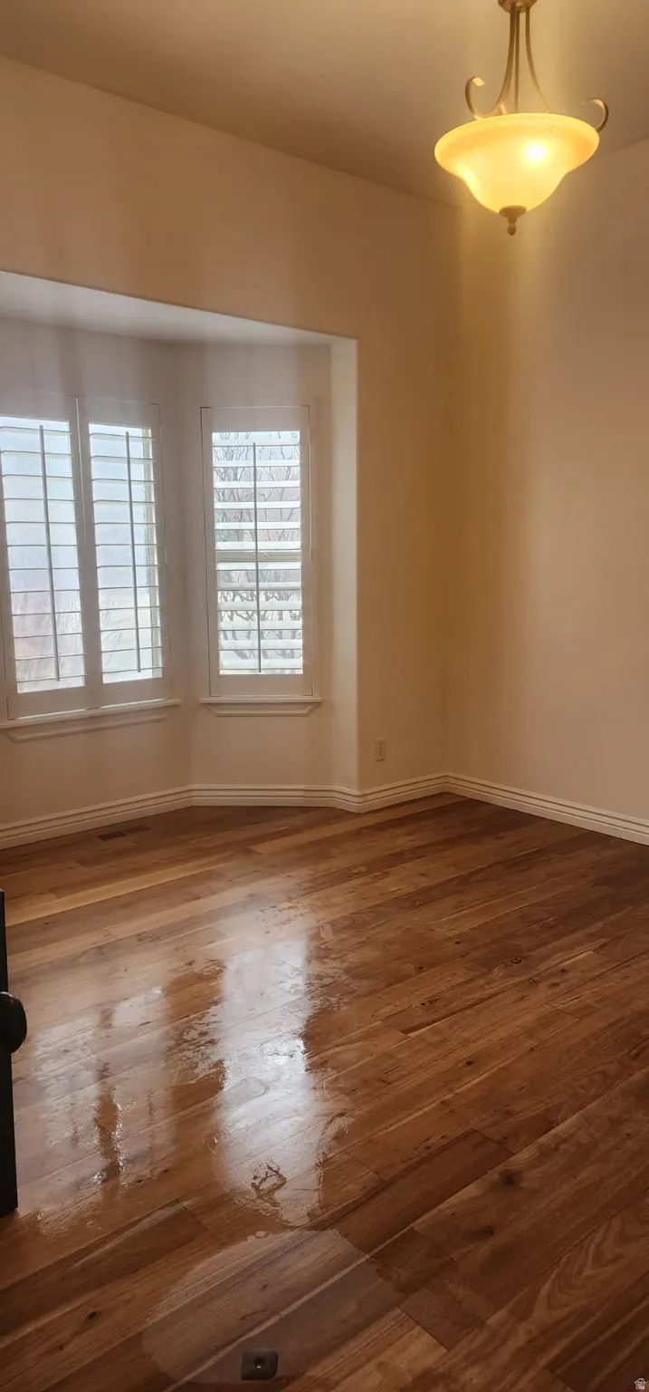Unfurnished room featuring dark wood finished floors and baseboards