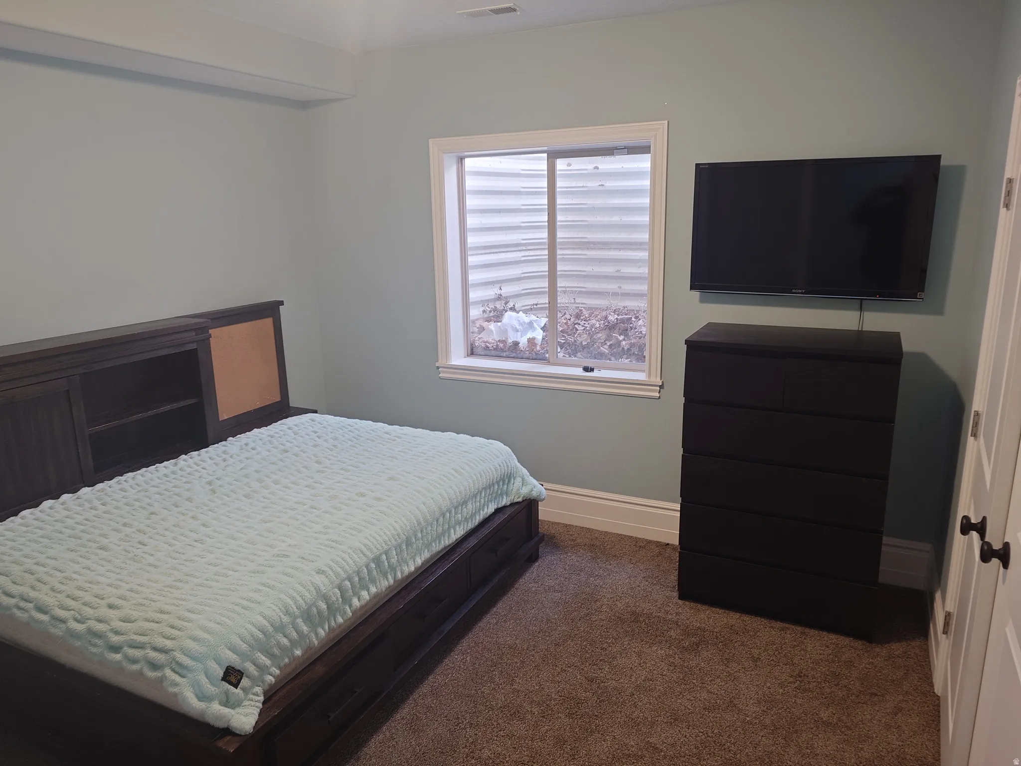 Carpeted bedroom featuring baseboards