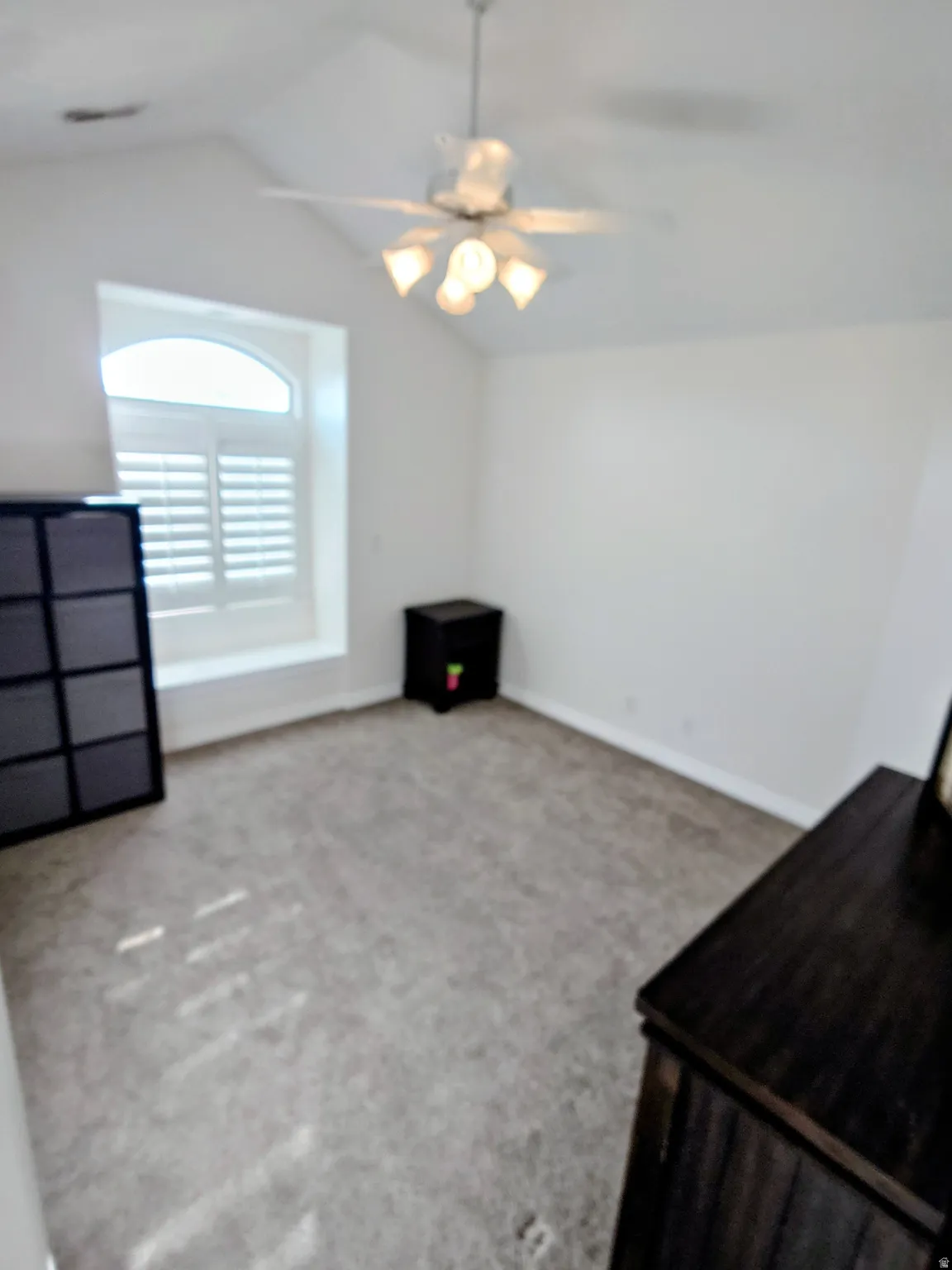 Unfurnished bedroom with lofted ceiling, carpet floors, and ceiling fan