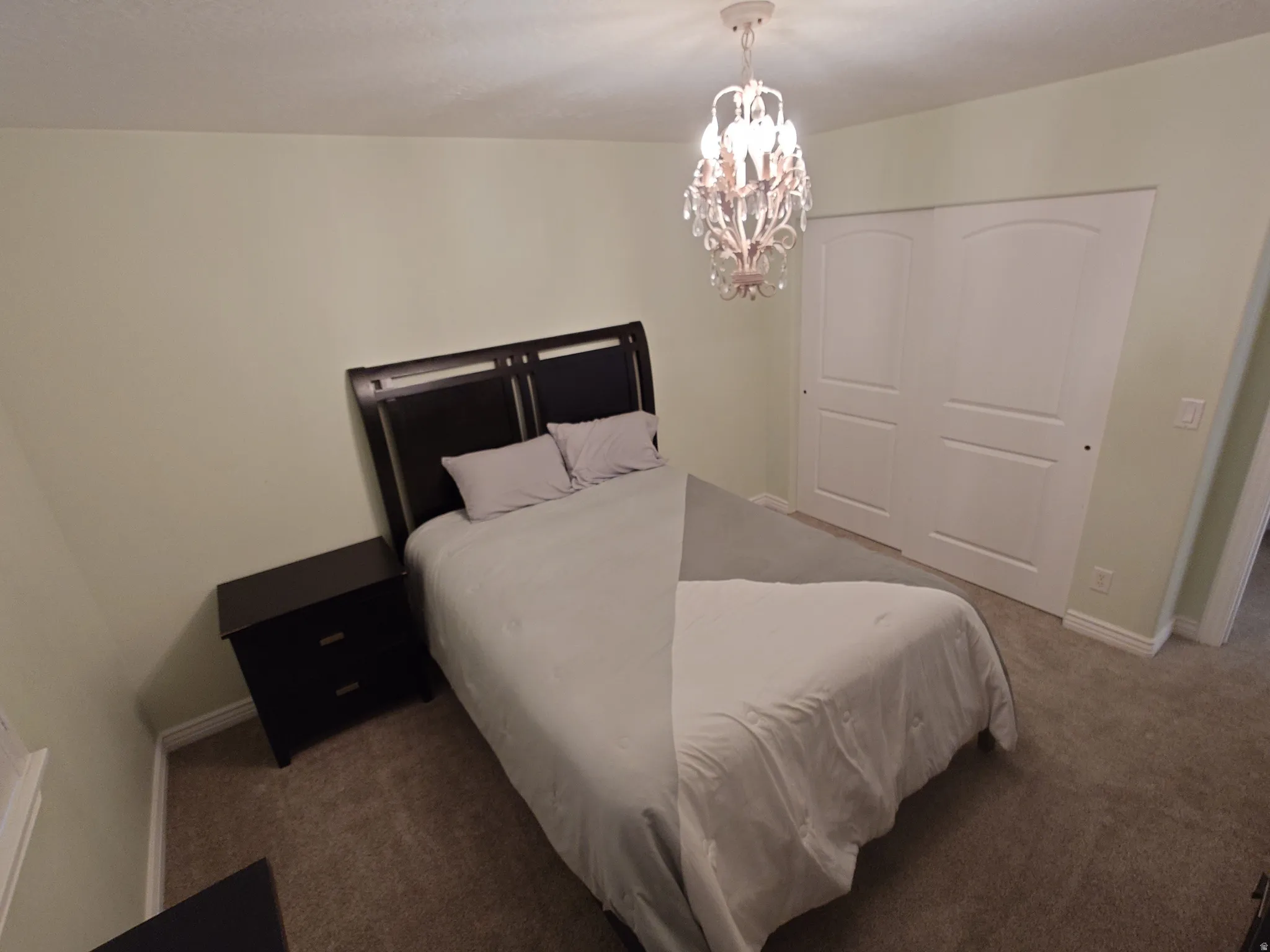 Bedroom with a chandelier, carpet, and a closet