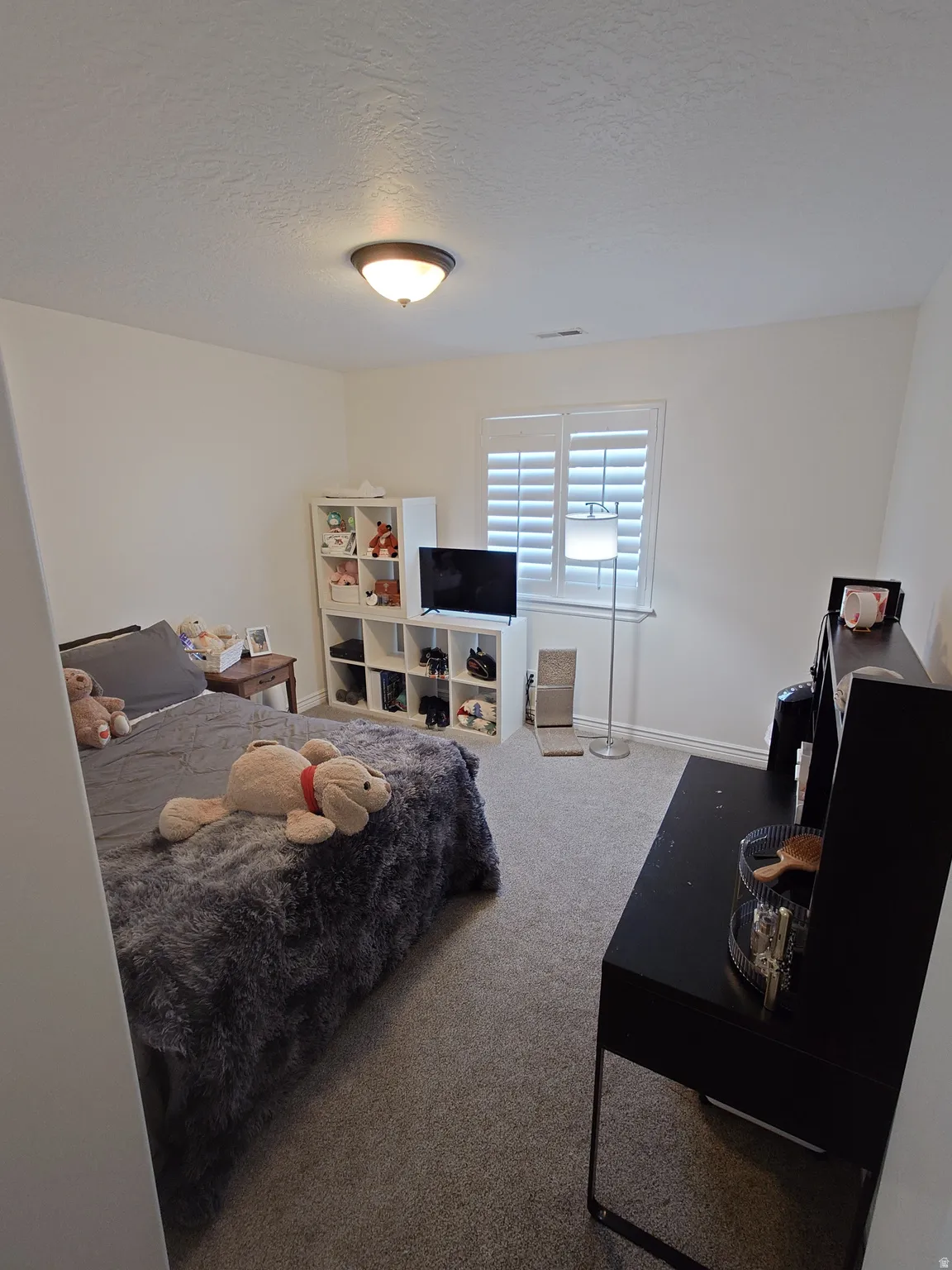 Bedroom featuring carpet and a textured ceiling