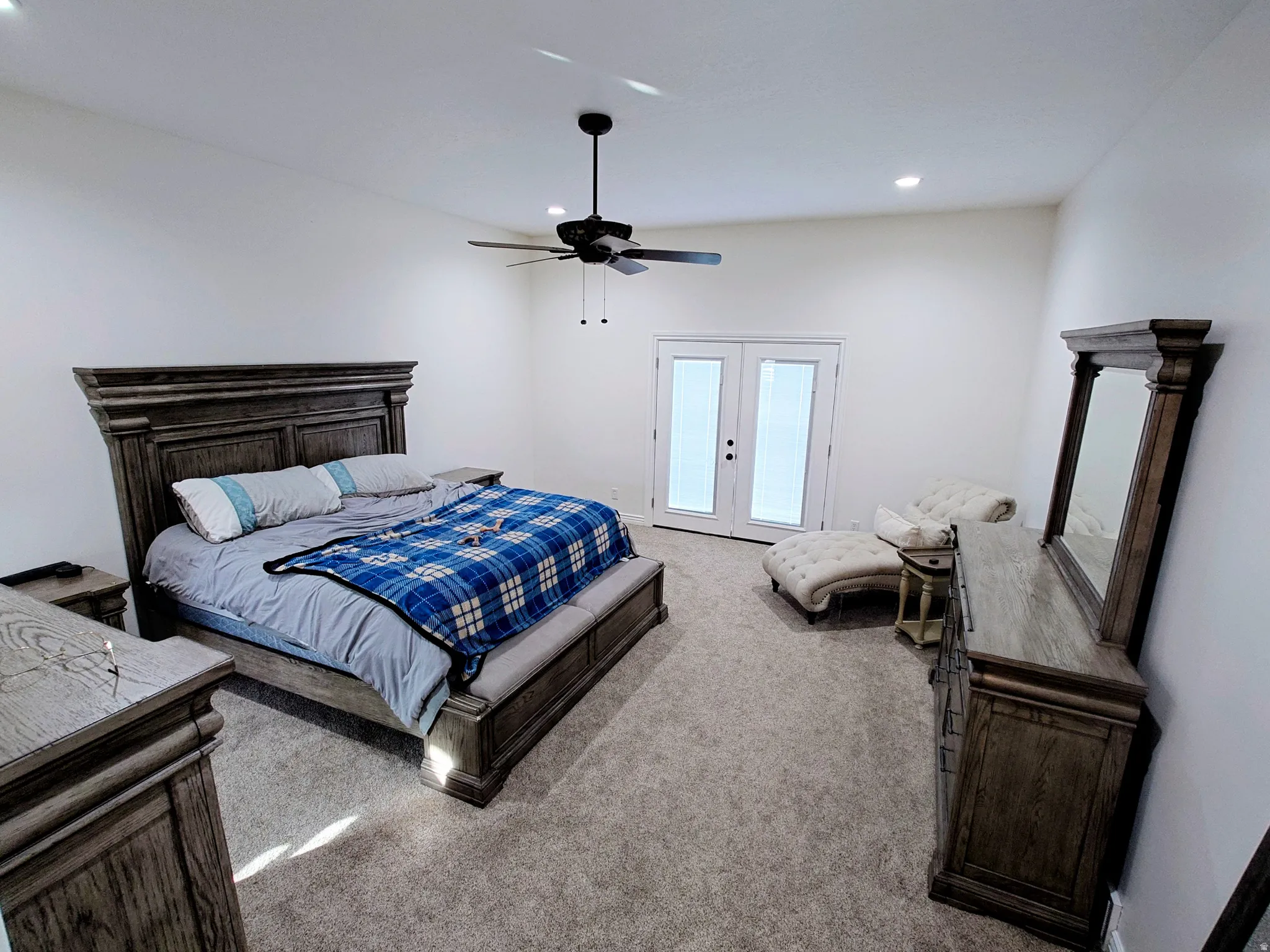 Carpeted bedroom with a ceiling fan, recessed lighting, and french doors