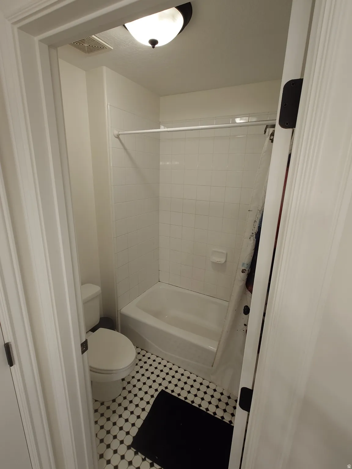 Full bath with shower / bath combination with curtain and toilet