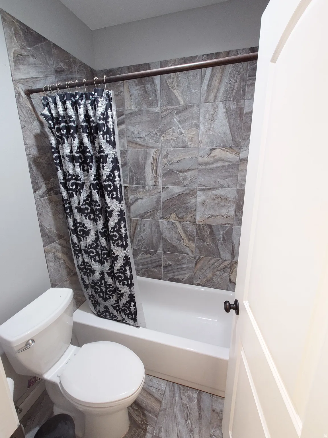 Bathroom featuring shower / tub combo with curtain and toilet