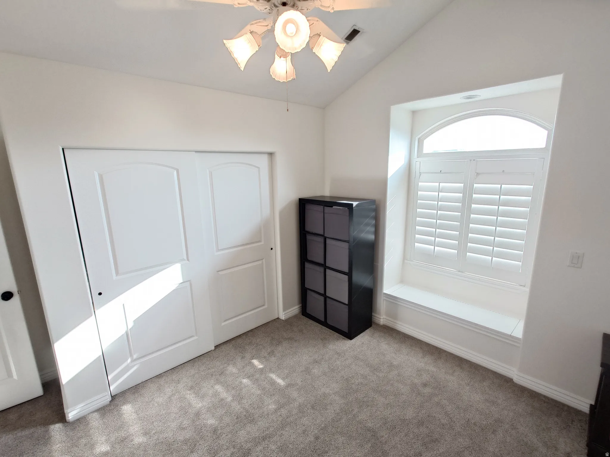 Unfurnished bedroom with vaulted ceiling, carpet flooring, ceiling fan, and a closet