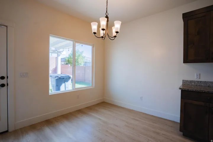 Unfurnished dining area featuring light wood-type flooring and a chandelier