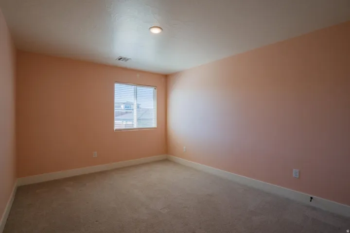 Spare room with light colored carpet and a textured ceiling