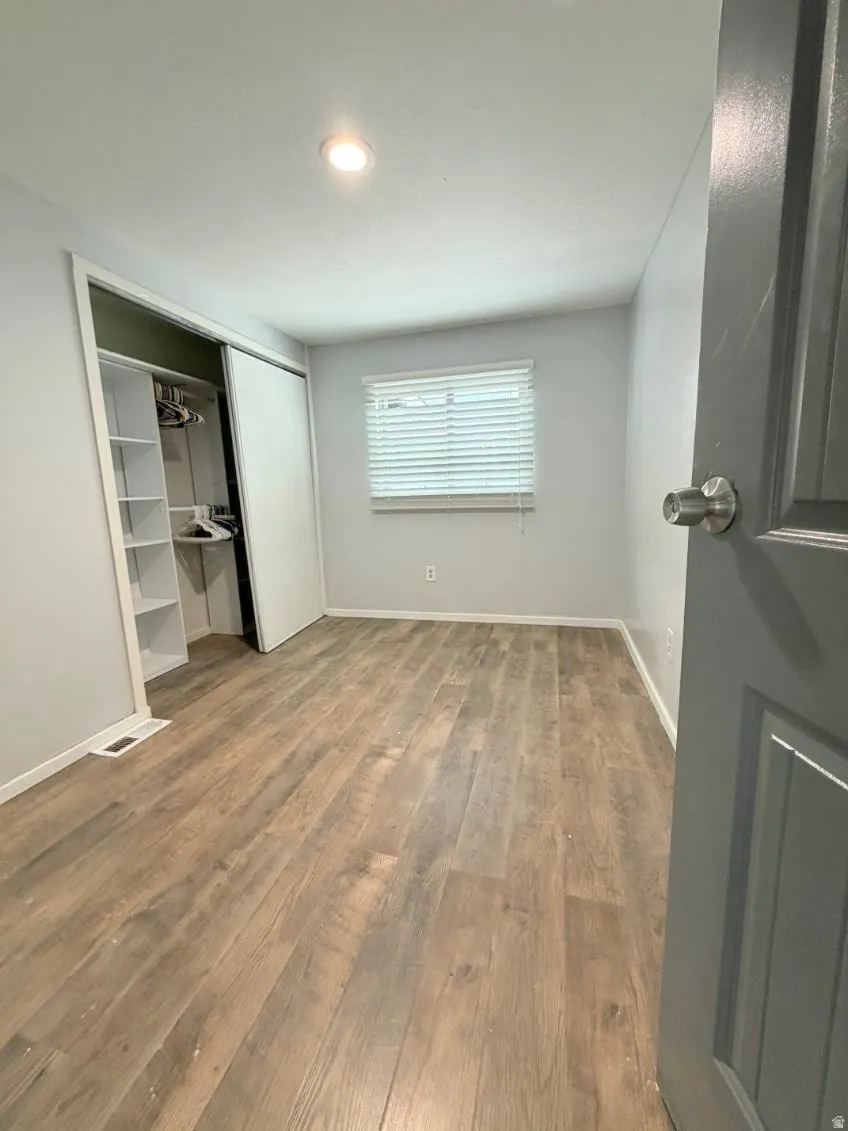 Unfurnished bedroom featuring light wood-type flooring and a closet