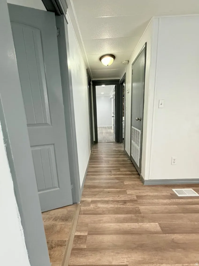 Hall featuring wood finished floors and a textured ceiling