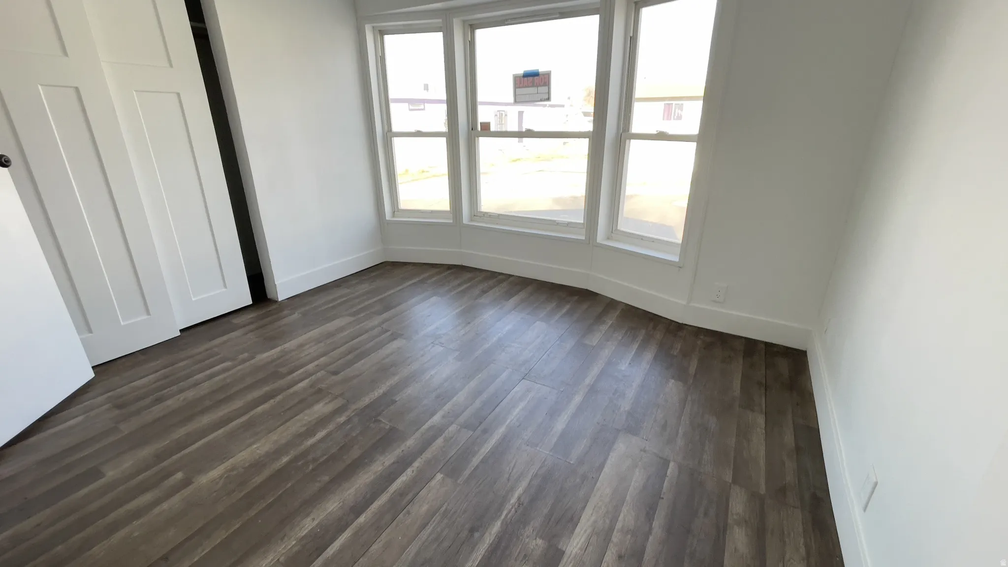 Unfurnished bedroom with a closet and dark wood-style floors