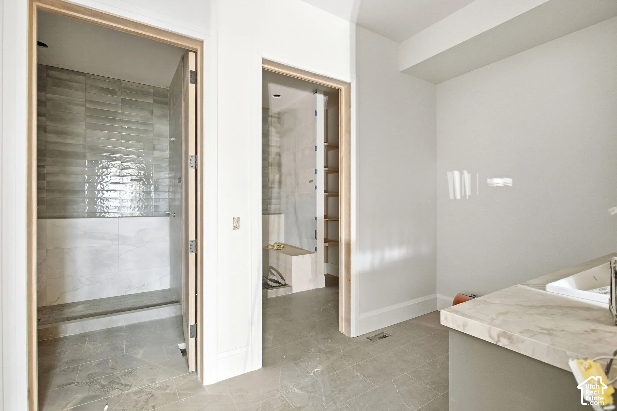 Walk-in shower with large format and subway tile, wood-finish door frames, and stone-look flooring
