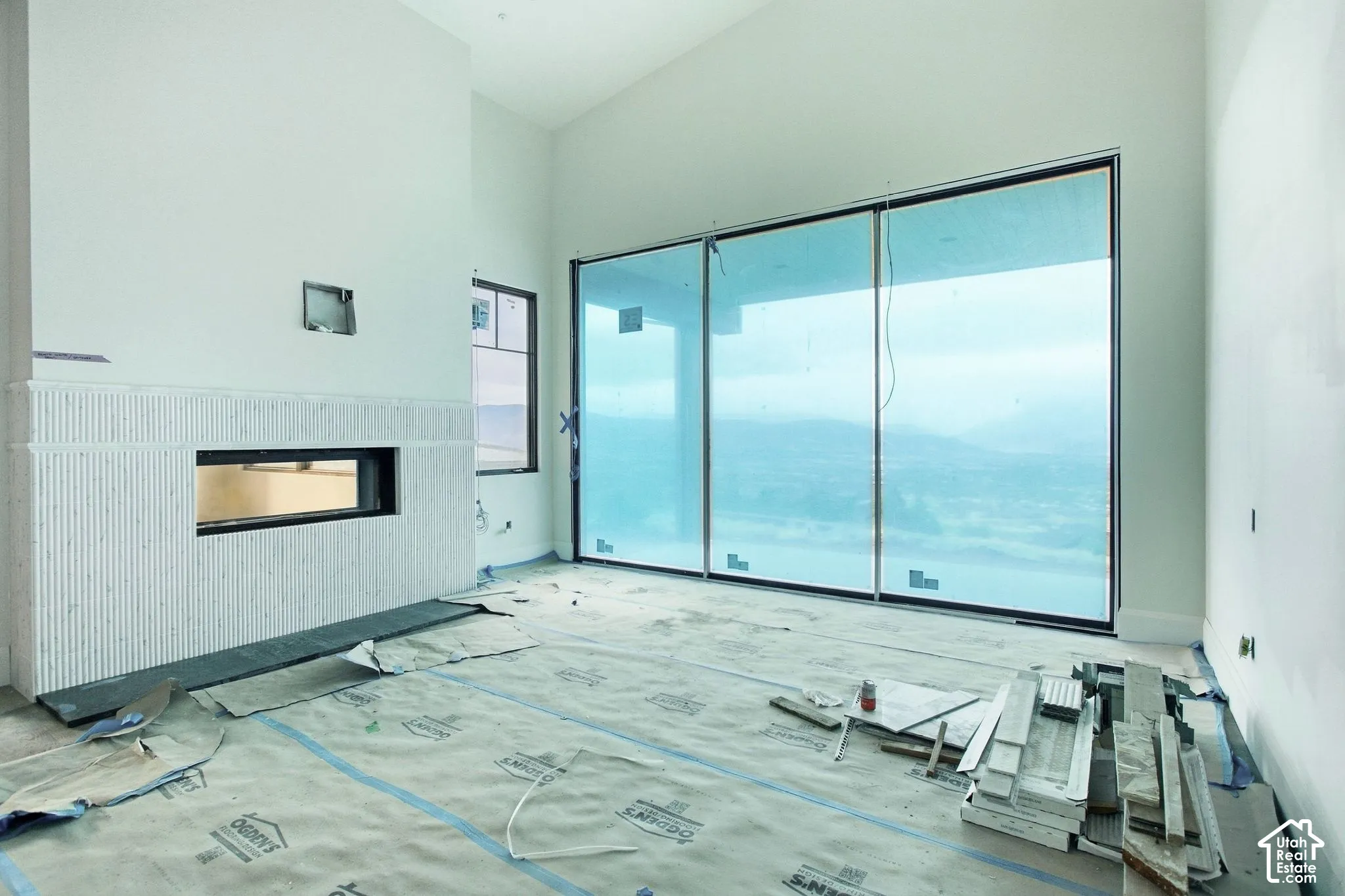 Vaulted ceiling, full-height tile fireplace with a linear firebox, and expansive sliding glass doors