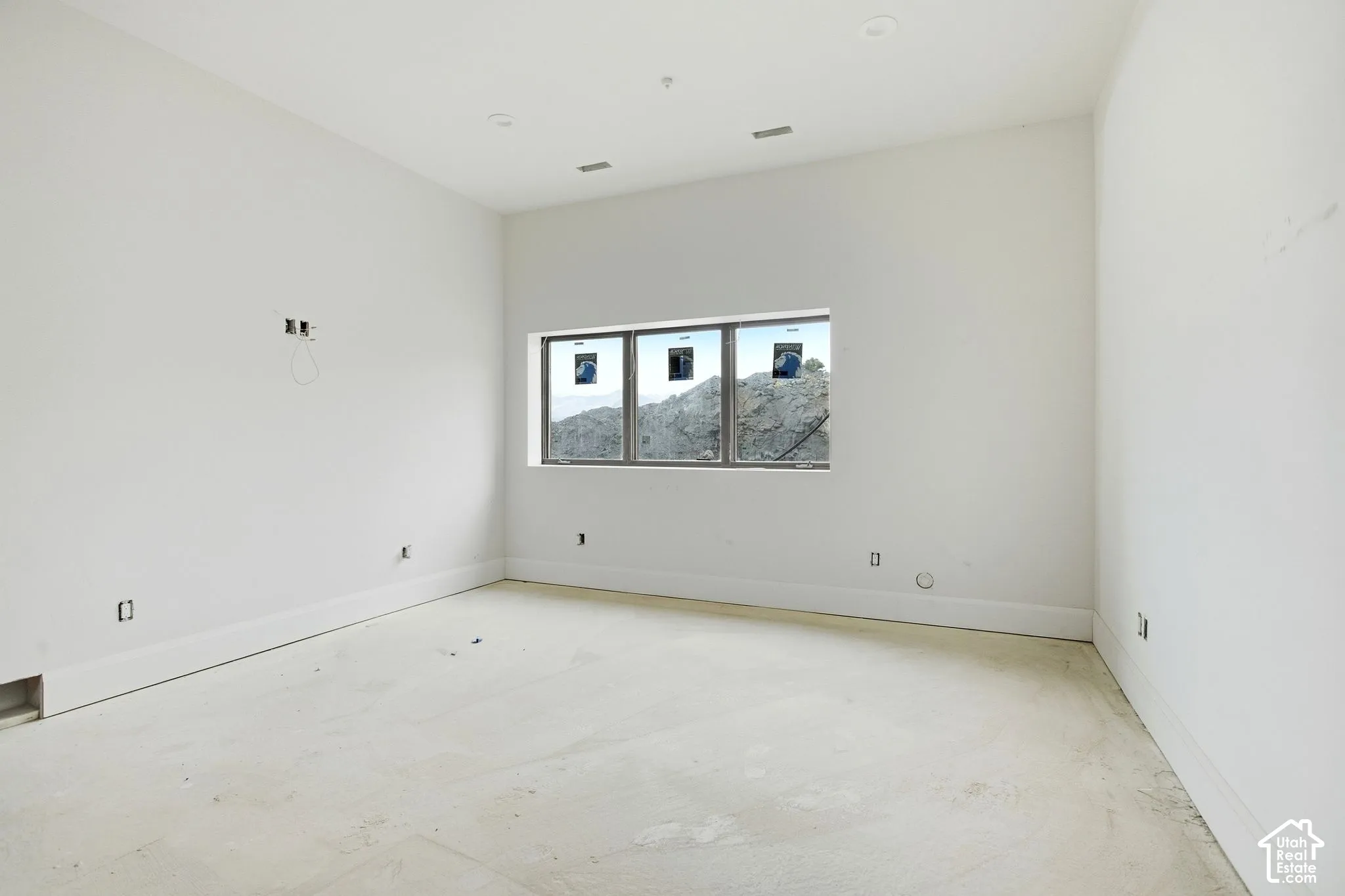 Unfinished interior space featuring a window with multiple panes and an exposed subfloor