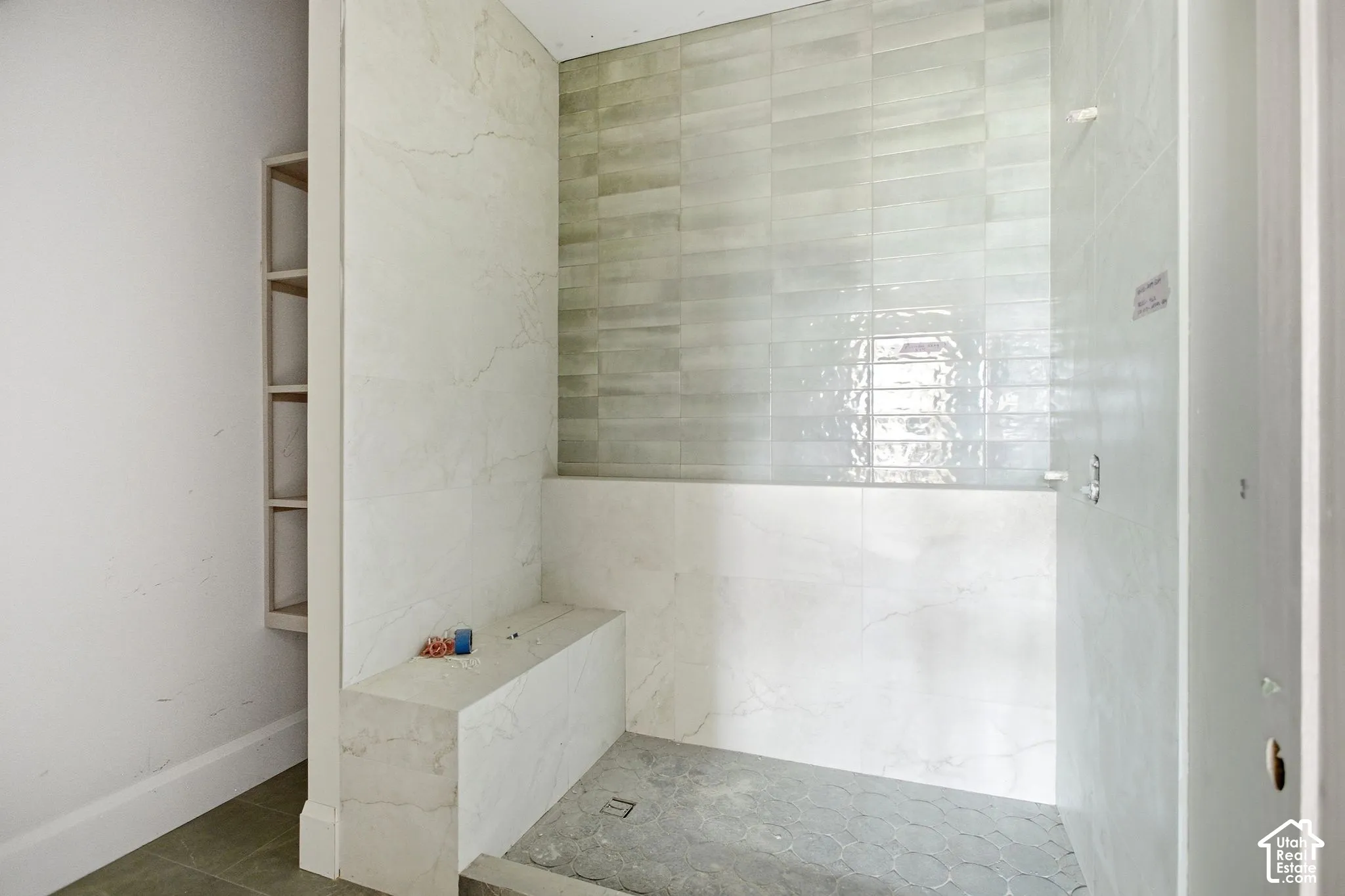 Shower with a built-in bench, tiled walls, and a tiled floor