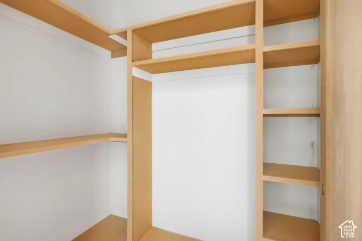 Built-in closet system featuring multiple wood-finish shelves and hanging space