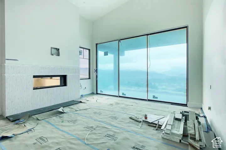 Vaulted ceiling, full-height tile fireplace with a linear firebox, and expansive sliding glass doors