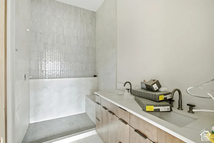Spacious shower with large format tile and a tiled bench