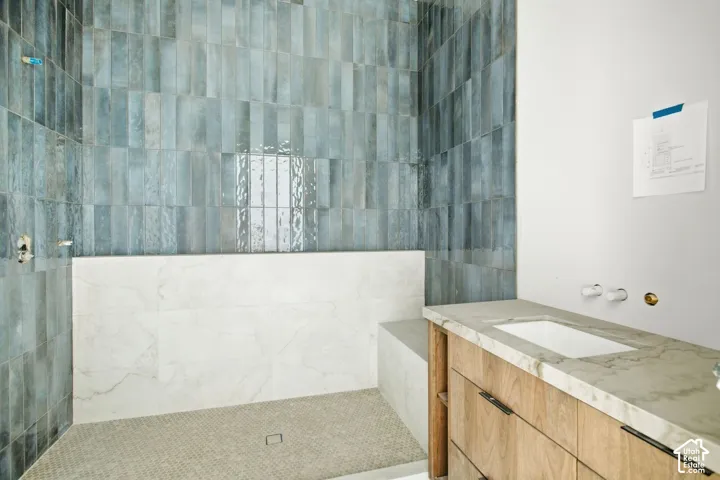 Shower featuring vertical blue tile, built-in bench with white tile, and mosaic floor tile
