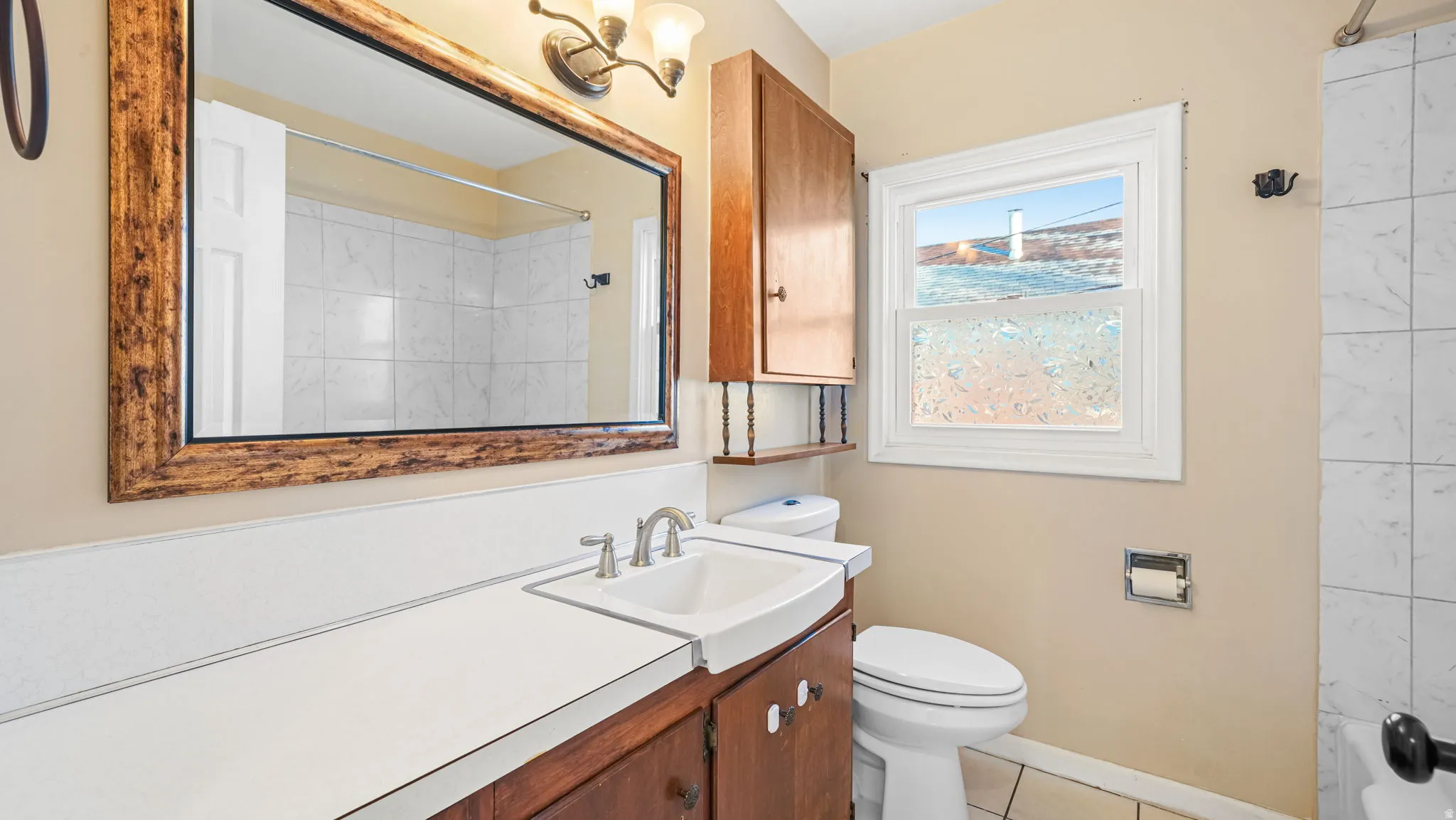 Bathroom with vanity, a shower, and light tile patterned flooring