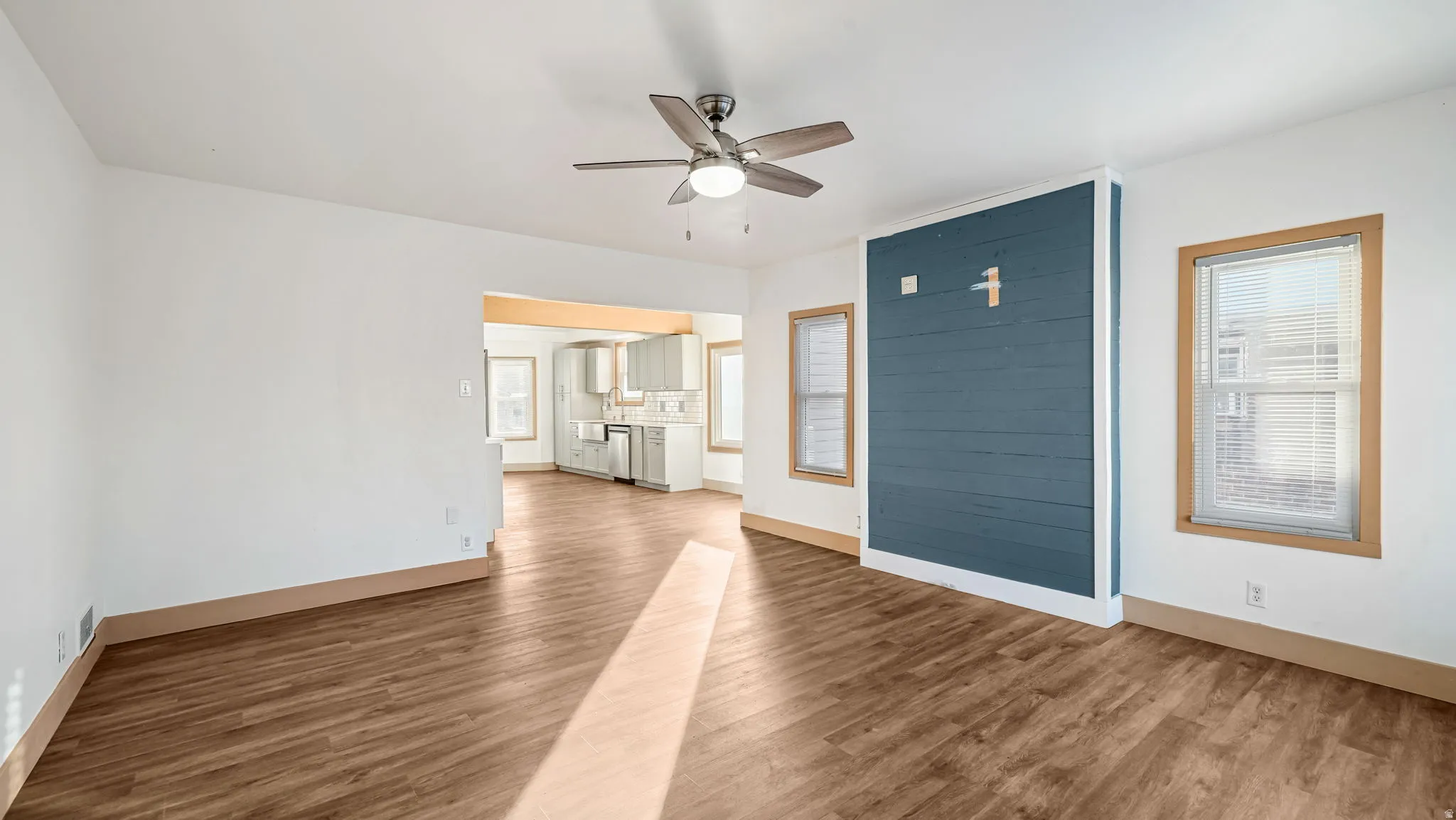 Unfurnished living room featuring light wood-type flooring and ceiling fan