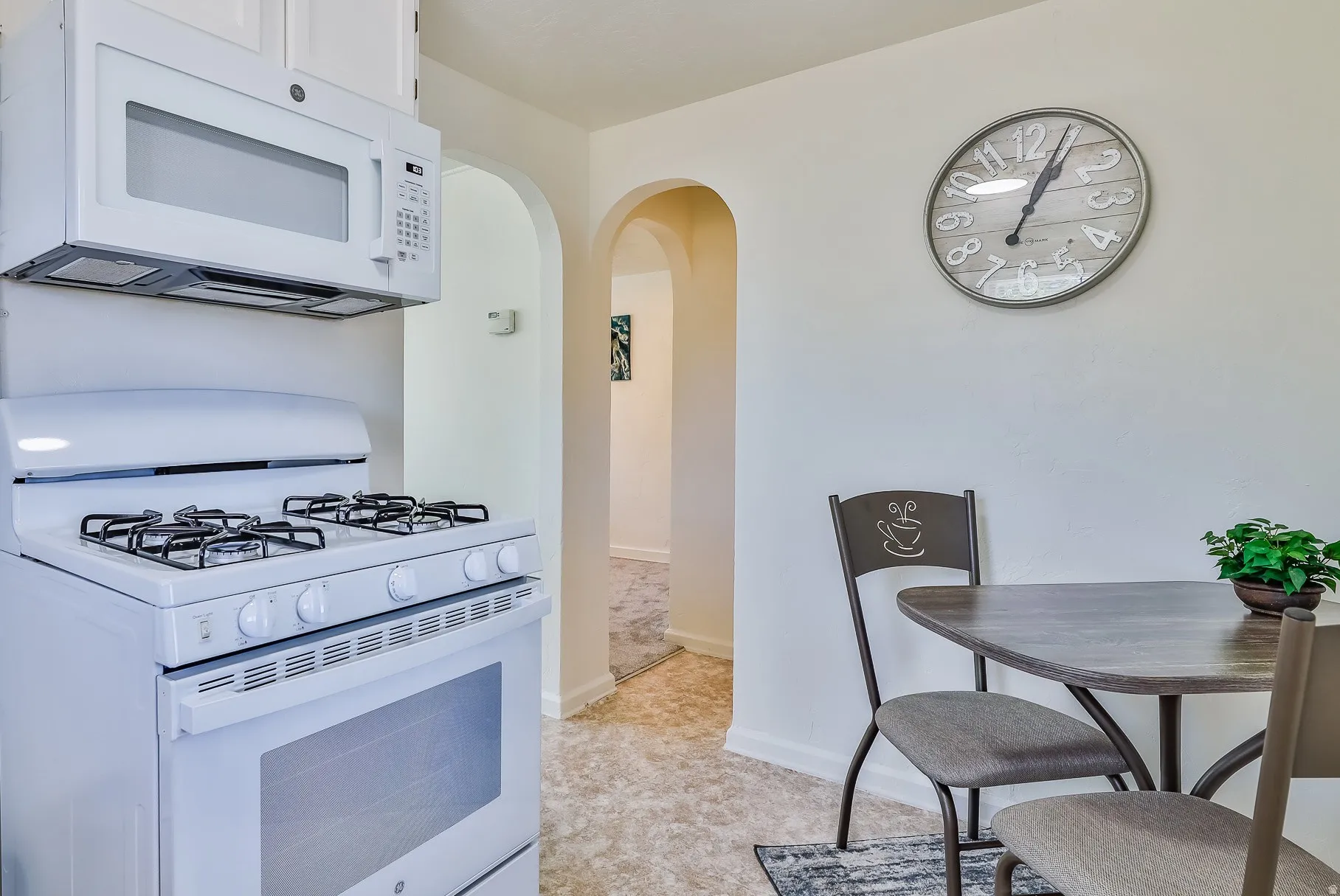 Kitchen featuring white appliances and arched walkways