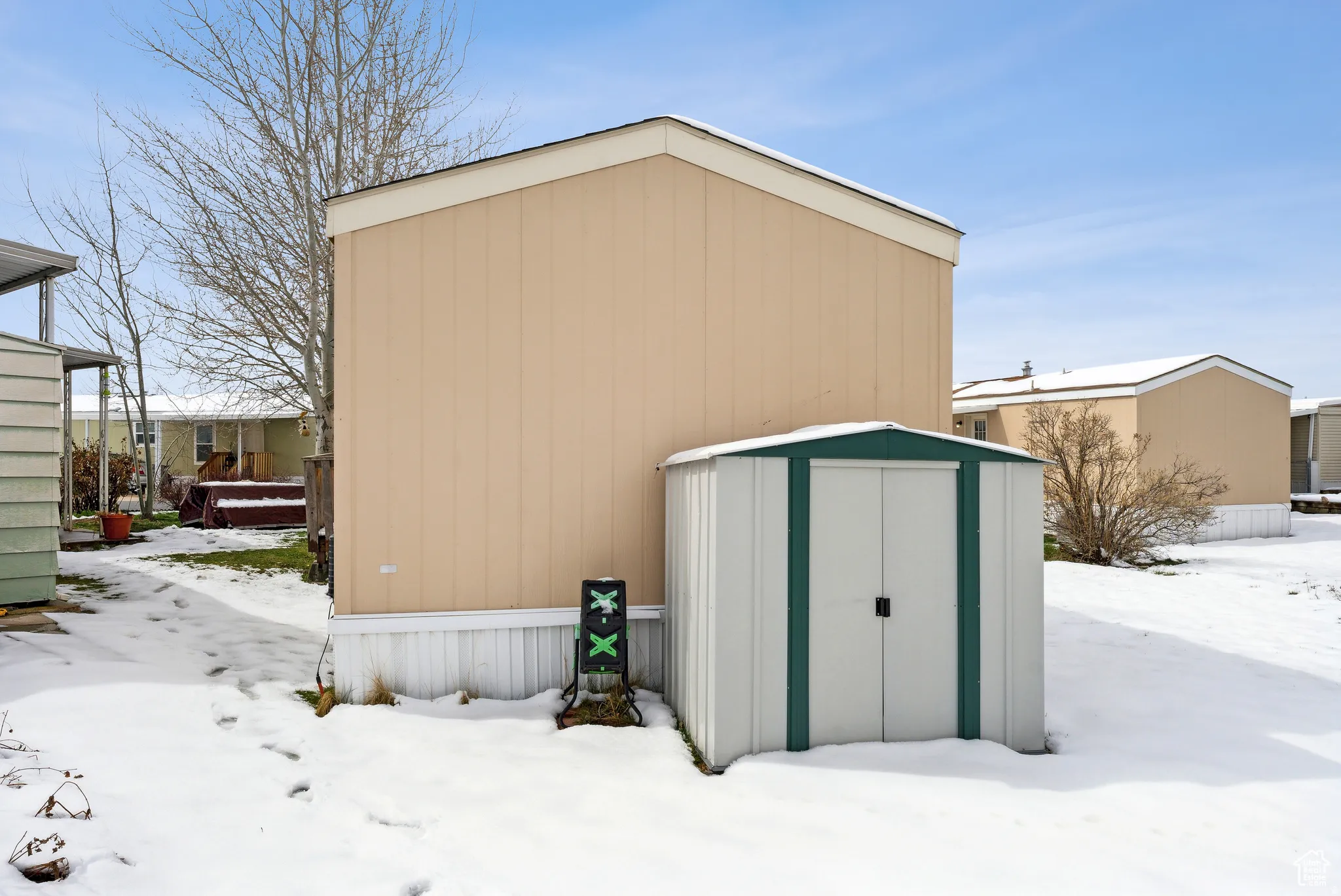 Snow covered structure featuring a shed