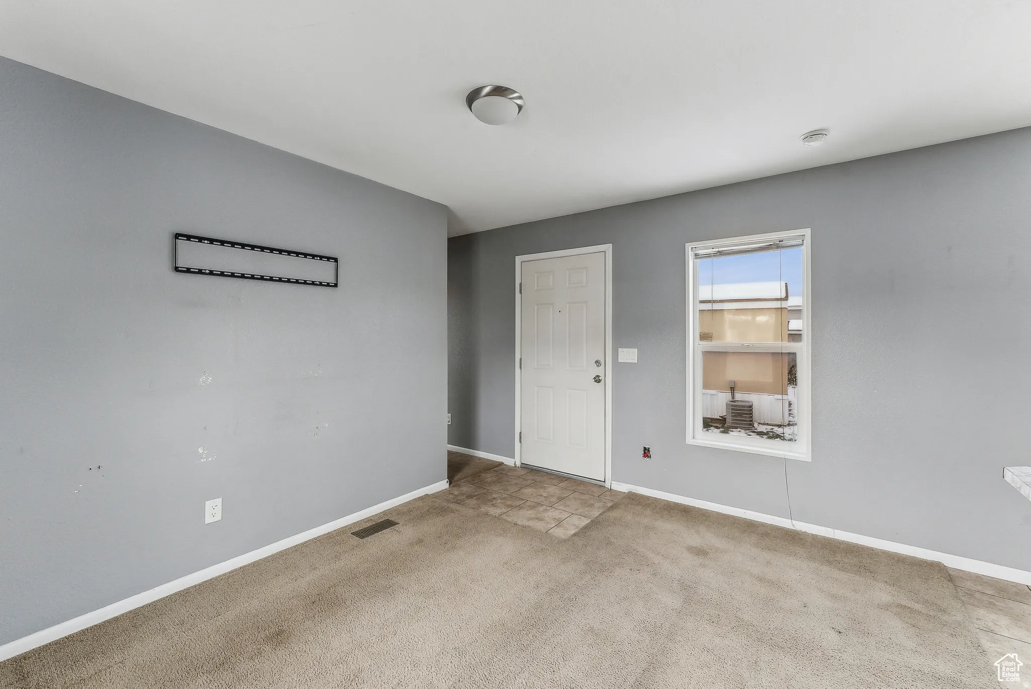 Empty room with carpet floors and baseboards