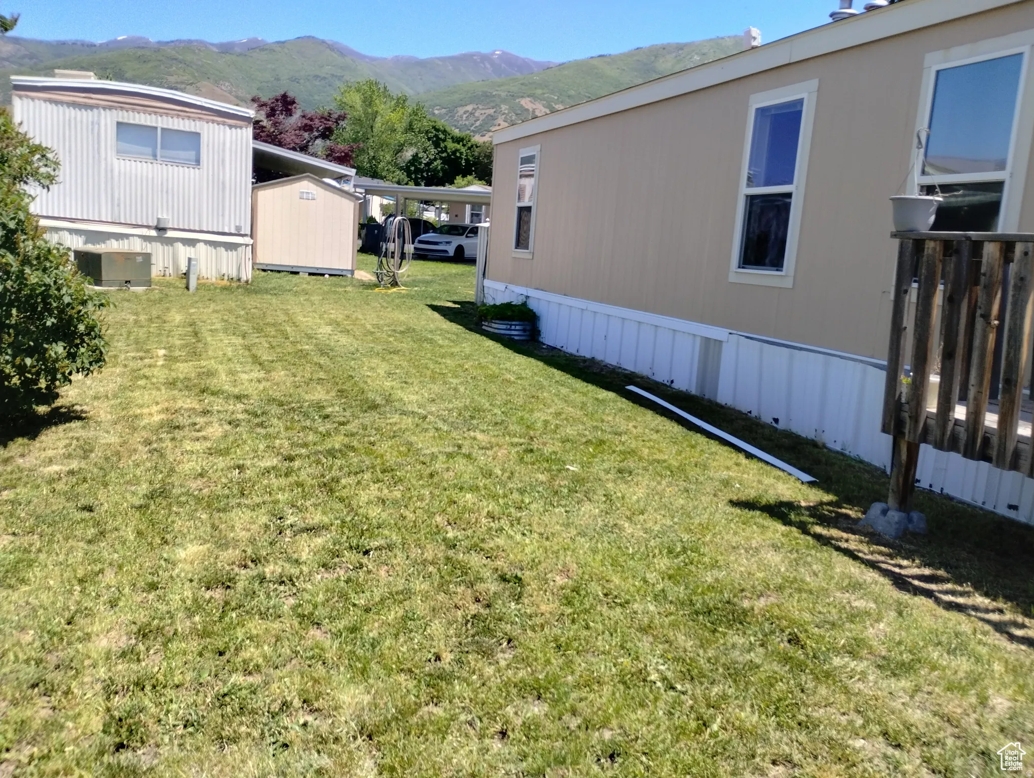View of green lawn featuring a mountain view and a storage unit