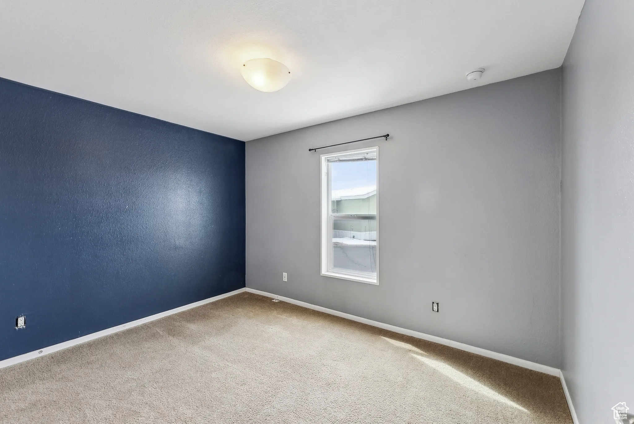 Empty room featuring carpet flooring and baseboards