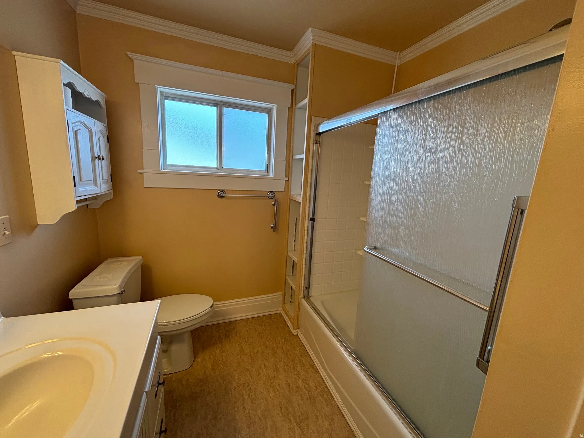 Full bathroom with vanity, enclosed tub / shower combo, ornamental molding, and light wood-style flooring