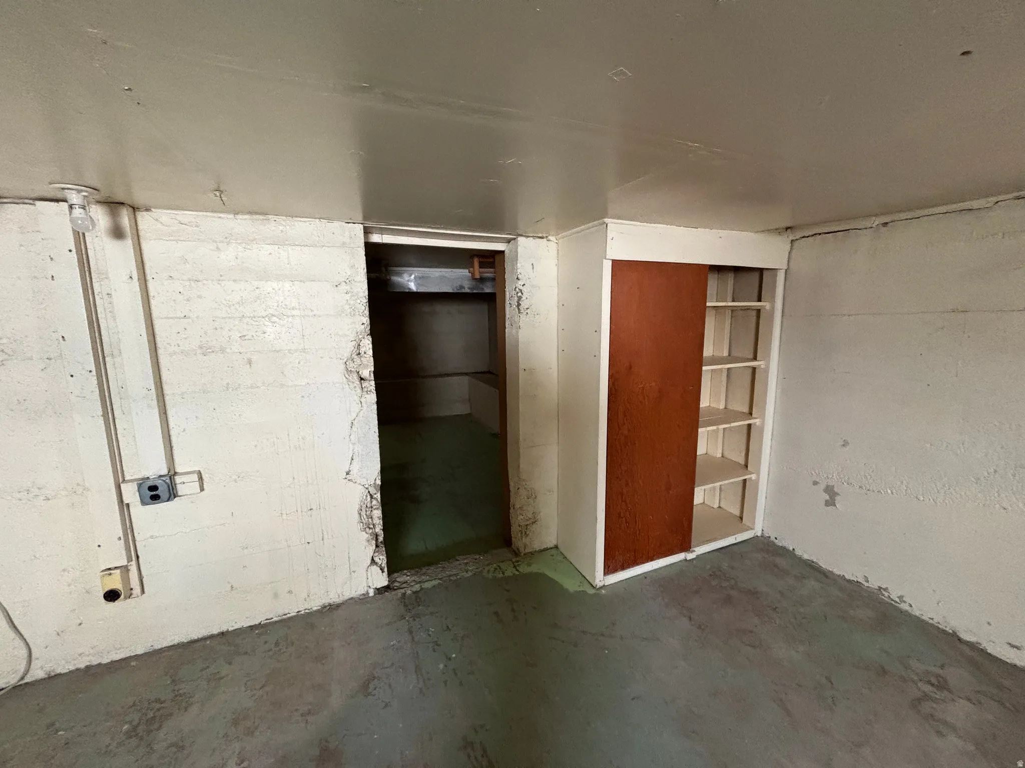 Unfurnished room with unfinished concrete flooring